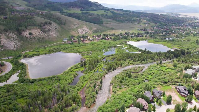 Aerial flight over a neighborhood and pond in Silverthorne, Colorado. Several ponds and the Blue River can be seen.