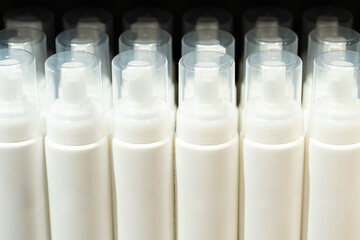 Blank White Cosmetic Bottles with Pump Dispensers. Skincare Product Packaging in Retail Display.