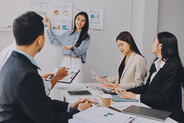 Team of financial advisory services. Asian advisor showing plan of investment to clients in the consultancy office..