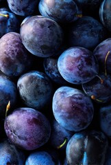 Fresh and Juicy Plums Arrangement on Dark Background for Culinary, Health, and Wellness Concepts, Creating a Rich and Vibrant Visual Appeal