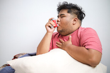 Young Asian Man Woke Up With Asthma Attack, Touching Chest and Using Inhaler
