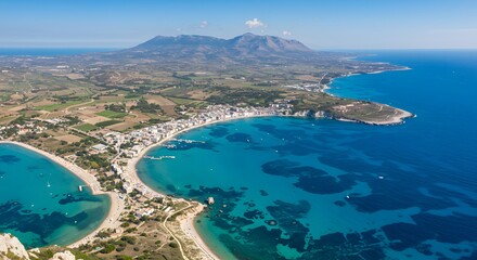 Obraz premium Coastal Town Aerial View with Clear Blue Water and Distant Mountains