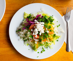 Delicious salad of fresh lettuce leaves, tomato, corn, onion, grated carrots and parsley with cottage cheese.