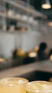 Row of three refreshing boba tea drinks in clear plastic cups with assorted colors, brown tapioca pearls against neutral background