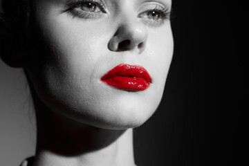 Black and white portrait of a woman with striking red lips, conveying elegance and sophistication, perfect for fashion and beauty themes.