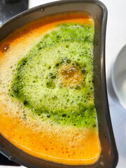 Fresh juice extraction with mixed vegetables and fruit  in juicer.The vibrant color blend showcases the juicing process, capturing the mix of healthy ingredients.