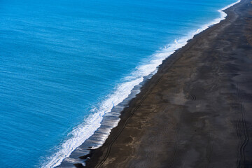 Black beach and blue sea in Dyrholaey of Vik, Iceland.