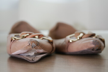 closeup of damage shoes on wooden floor 
