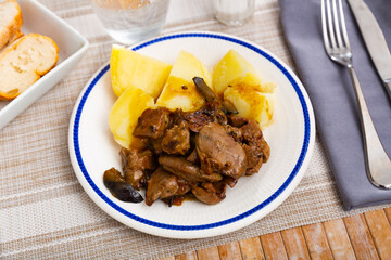 Rabbit liver fried with onion garnished with baked potato