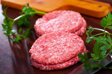 Image of raw burger cutlet and greens before cooking, nobody