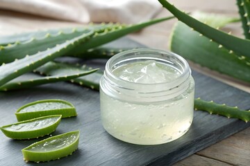 Aloe Vera Gel in Glass Jar with Sliced Leaves on Dark Wood Surface