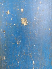 Old Blue Painted Surface with Peeling and Scratches. Close-up of a weathered blue painted wall with peeling paint and surface scratches, ideal for texture backgrounds or grunge designs