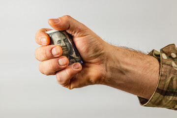 Hand squeezing a dollar bill with soft focus background