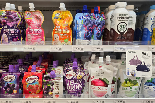 Penang, Malaysia &ndash; May 12, 2024: A selection of jelly drinks and protein shakes neatly arranged on the shelves at FamilyMart, featuring popular brands like Ribena, Origina, Rokeby, and Dolphin.