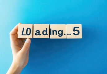 Hand Holding Wooden Blocks Spelling Loading