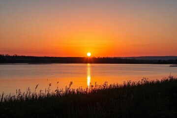 Obraz premium sunset over a lake with a boat in the distance