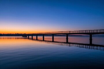 Fototapeta premium arafed bridge over a body of water with a sunset in the background