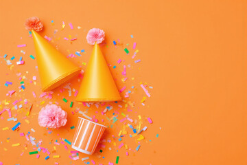 party hat streamers and confetti on an orange background