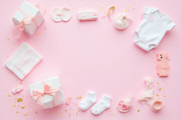 pink and white baby items on a pink background with confetti