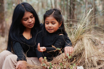 Indigenous mother and daughter exploring nature, discovering wildlife