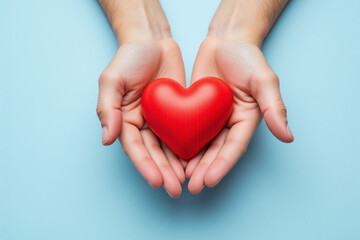 Obraz premium two hands holding a red heart on a blue background 2