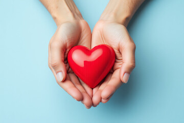 Fototapeta premium two hands holding a red heart on a blue background 1