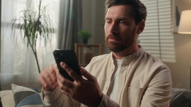 Angry man Caucasian guy male businessman stressed annoyed upset problem mobile phone app breakdown low internet message bad news frustrated emotional mad furious trouble smartphone rejection at home