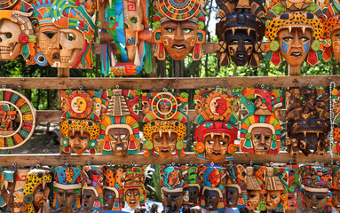 Many colorful traditional Mayan mask souvenirs up for sale within the ruins of Chichen Itza, Mexico