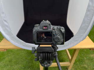 DSLR camera shooting toy tractor in portable light tent studio closeup view