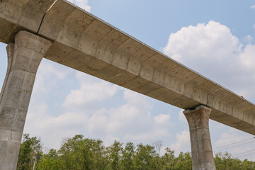 An elevated train track undergoing construction outside the city in the afternoon