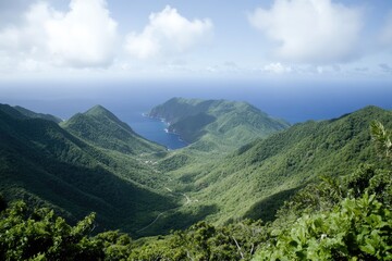 Lush valley nestled within rugged mountains, overlooking turquoise ocean