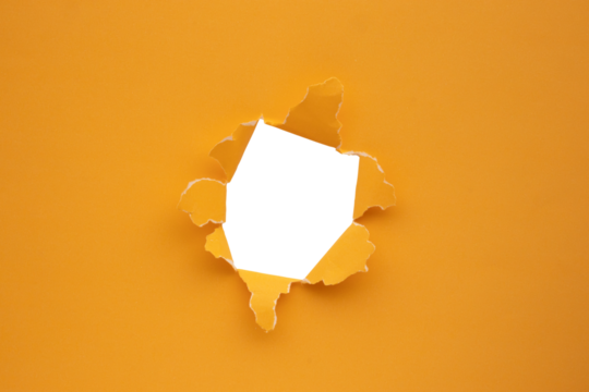 Torn ripped orange paper hole isolated on white background