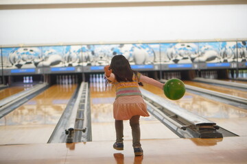 ボーリングを楽しむ小学2年生の女の子の後ろ姿
