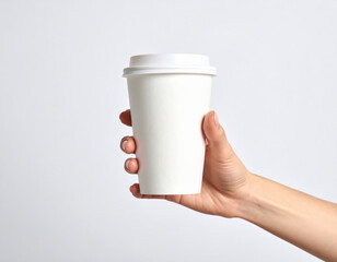 Woman hand holding white disposable paper cup with lid on white background