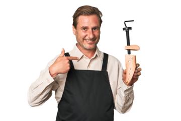 A middle-aged shoe maker person pointing by hand to a shirt copy space, proud and confident