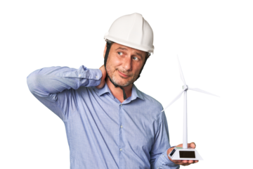 A middle-aged architect man holding a windmill model touching back of head, thinking and making a choice.