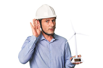 A middle-aged architect man holding a windmill model trying to listening a gossip.