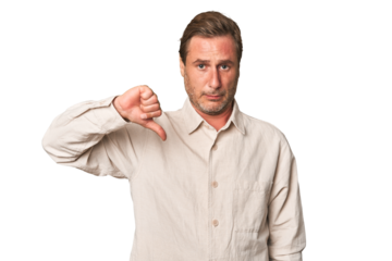 A middle-aged man isolated showing a dislike gesture, thumbs down. Disagreement concept.