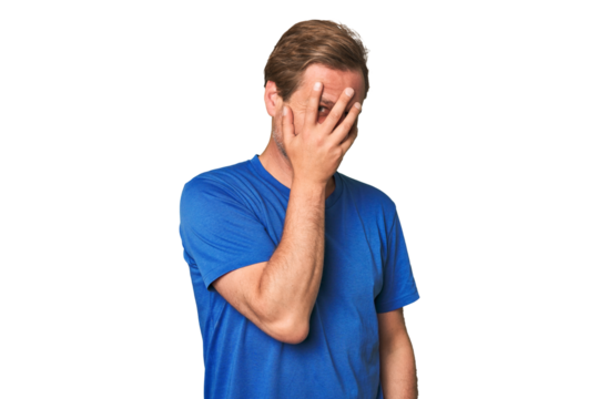 A middle-aged man isolated blink at the camera through fingers, embarrassed covering face.