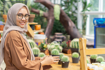 Small business owner of plant cactus shop smilling and wearing hijab