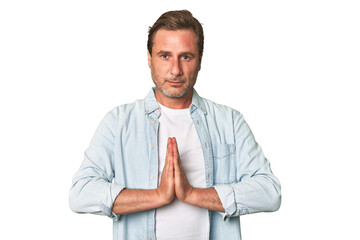 A middle-aged man isolated praying, showing devotion, religious person looking for divine...