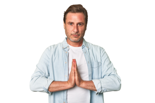 A middle-aged man isolated praying, showing devotion, religious person looking for divine inspiration.