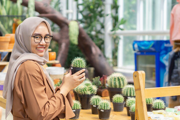 Small business owner of plant cactus shop smilling and wearing hijab