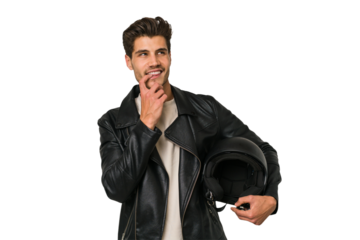 Young caucasian man holding a motrbike black helmet isolated relaxed thinking about something looking at a copy space.