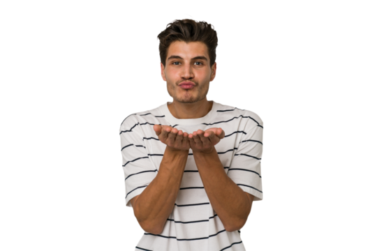 Young handsome caucasian man isolated on white background folding lips and holding palms to send air kiss.