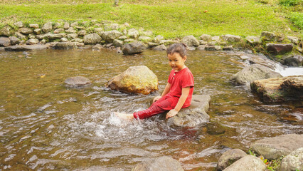A daughter playing in a river with red clothes