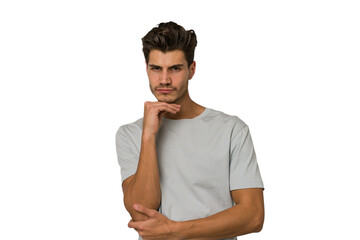 Young handsome caucasian man isolated on white background suspicious, uncertain, examining you.