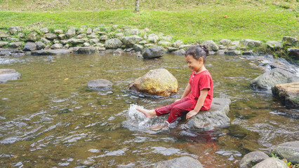 A daughter playing in a river with red clothes