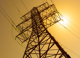A tall power tower with a sun shining on it
