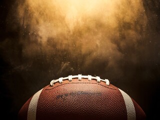 A close-up of a textured football against a dramatic, hazy background.